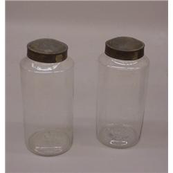 TWO BLOWN GLASS CANISTERS. Tin lids (wear). 4 1/2"d. 10 1/4"h. and 4 1/2"d. 10"h.…
