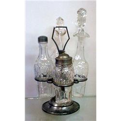 TWO GLASS PIECES: Four-bottle, mold blown caster set in a pewter holder. Two cruets, shaker, and …