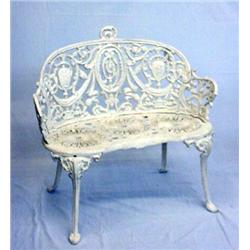 TWO PIECES OF CAST IRON GARDEN FURNITURE. Old white paint. Settee with kidney shape seat. Medalli…