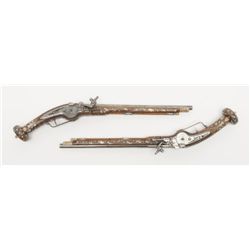 Pair of ornate wheellock pistols showing  elaborately inlaid stocks in Germanic style  measuring 26 
