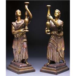 PAIR OF CARVED AND GILT WOOD FIGURES, in classical robes holding candlesticks on stepped rectangu...