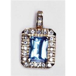 14K YELLOW GOLD ENHANCER, set with a fancy rectangular cut blue topaz (approx. 9.40ct.) within a...
