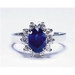 PLATINUM RING, set with an oval cut sapphire (approx. 1.20ct.) encircled by 10 brilliant cut diam...