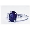 Image 1 : PLATINUM RING, set with a fine oval cut sapphire (approx. 2.50ct.) flanked by 2 small tapered bag...