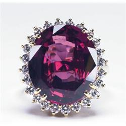 18K YELLOW GOLD COCKTAIL RING, set with a large oval cut rhodolite garnet (approx. 12.0ct.) encir...
