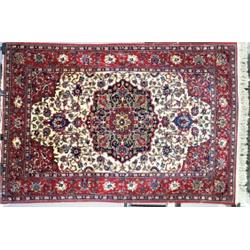 A FINE ISPHAHAN RUG, central Persia, c.1930, with a floral filled ivory field containing a blue g...