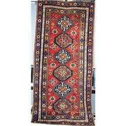 A GENJE LONG RUG, central Caucasus, c.1910, the pale red field containing six latchhooked meddall...
