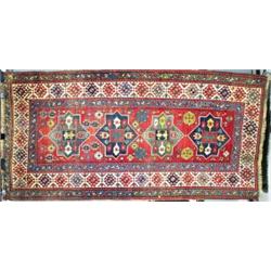 A BERGAMA LONG RUG, western Turkey, c. 1920, the rust/red field containing four eight point star...
