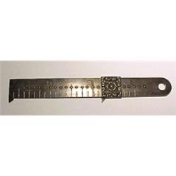England, c. 1875, a silver three inch ruler with a sliding marker which is decorated by a rosett...
