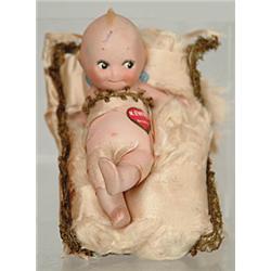 RARE CHARACTER KEWPIE BISQUE DOLL ON PILLOW.