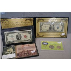 An American red seal $2 bill, two blue seal $1 bills, 2012 JFK half dollar and a Sacagawea 2012 doll