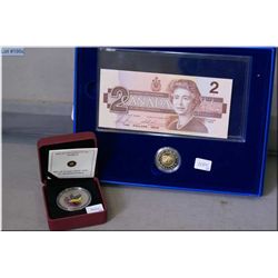 Boxed 1986 two dollar bill and toonie set plus a 2010 twenty five cent colour coin "Gold Finch"