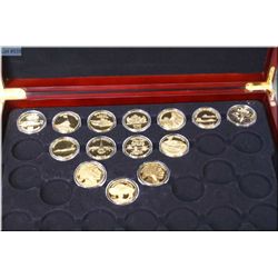 Fourteen cased selection of sterling silver with gold cladding tokens depicting military etc. in pre
