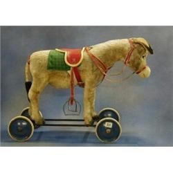 A childs 1950's Steiff push-a-long figure of a donkey with working bray   £150-200...