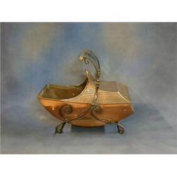 An Art Nouveu embossed copper boat shaped coal scuttle raised on iron supports   £75-125...