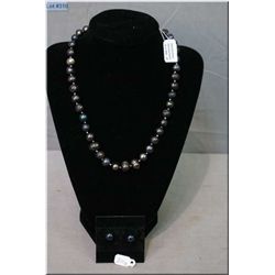 An 18" strand of hand knotted genuine 10-11mm opalescent blue to black freshwater pearls with sterli