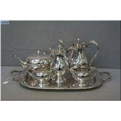 Silverplate tea service including tea pot, coffee pot, hot water, cream and sugar on a double handle