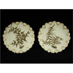 A pair of Royal Worcester dessert plates with a gilded fern leaf pattern on a cream ground, date...