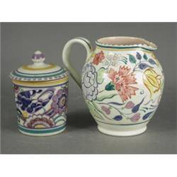 Two Poole pottery items: A pot and cover and a milk jug (2) Est. 120/150...