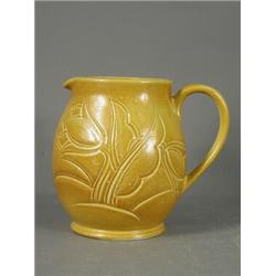 A Susie Cooper brown moulded single handled jug, with incised decoration, marked to base, 17cm Es...