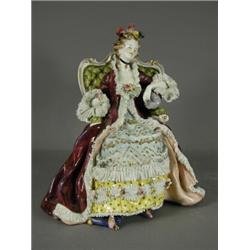 A Volkstedt figure of a seated lady in 18th century costume, with Capo de Monte style mark, 33cm...