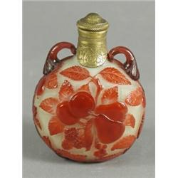 A cameo glass scent bottle overlaid in red glass with fruiting foliage on an opaque ground below...
