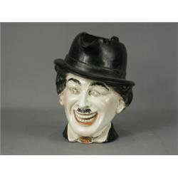 An early 20th century porcelain character jug inscribed 'Charlie Chaplin', with impressed numbers...
