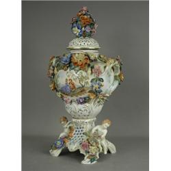 A large Dresden vase and cover, decorated with floral sprigwork, two painted cartouches, with two...