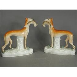 A pair of Staffordshire greyhounds with rabbits in their mouths, (one leg and base damaged), 18cm...