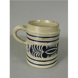 An 18th century Westerwald tankard, with a moulded seal mark initialled 'G.R.', heightened in blu...