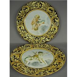 A pair of early 20th century maiolica chargers painted with cherubs, 43cm diameter Est. 150/200...