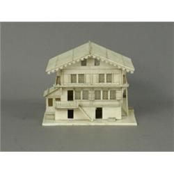 A carved bone model of a chalet with a hinged roof and fitted interior, 10cm high Est. 70/150...