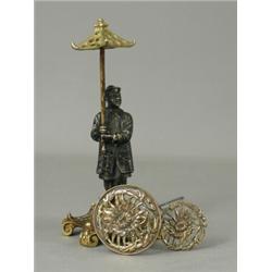 A bronze hat pin holder in the form of a chinaman holding a pagoda shaped umbrella, with two hat...