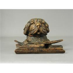 A Bavarian carved softwood ink stand, the dog's head hinged to reveal a glass inkwell, 18cm long...