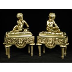 A pair of late 19th/early 20th century French gilt bronze chenets, each with a cherub on a tassel...