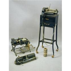 An Ediphone dictaphone on a stand, an Edison shaving machine, one other machine with cylinders an...