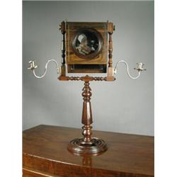 A rosewood Zograscope on a turned and inlaid stand, with brass candle sconces either side, 19th c...