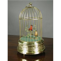 A brass musical automaton modelled as a cage with two birds, with label to reverse, 'The Merry Mu...