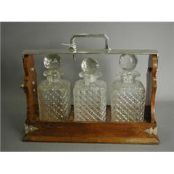 An oak tantalus with matched decanters and plated mounts Est. 150/200...