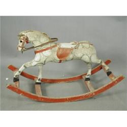 An early 20th century childs rocking horse with a padded body and wooden base, possibly Eastern E...