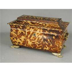 A good Regency tortoiseshell teacaddy of bombe shape, with foliate gilt side handles, on winged l...