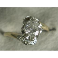 A diamond solitaire (approx 1ct) crossover ring with diamond set shoulders (one missing), set in...