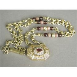 A French designer ruby and diamond pendant, set in gold, 2.5cm long, to a fancy link chain with d...