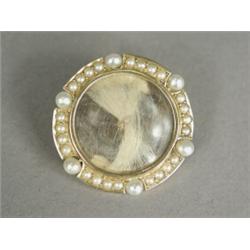 A 14k gold memorial brooch/pendant set with hair within a seed pearl frame, 3cm in diameter (case...