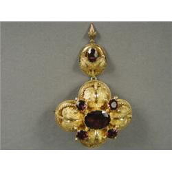 A Victorian stomacher brooch set with almandine garnets, the whole embossed with leaves and with...