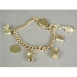 A 9ct gold curblink charm bracelet with six various charms, a heart locket and safety chain, 18cm...