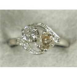 An 18ct white gold two-stone twist diamond ring, one stone cushion cut, tinted, the other round b...