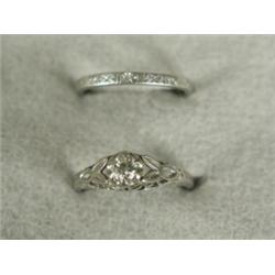 A platinum mounted diamond solitaire ring within pierced and engraved shoulders and engraved shan...