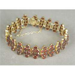 A garnet set fancy link bracelet set in yellow metal (tests gold) with a safety chain, 16cm long...