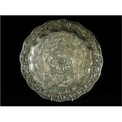 A Chinese silver dish, with a central chased panel of oriental figures, within bamboo and bird de...